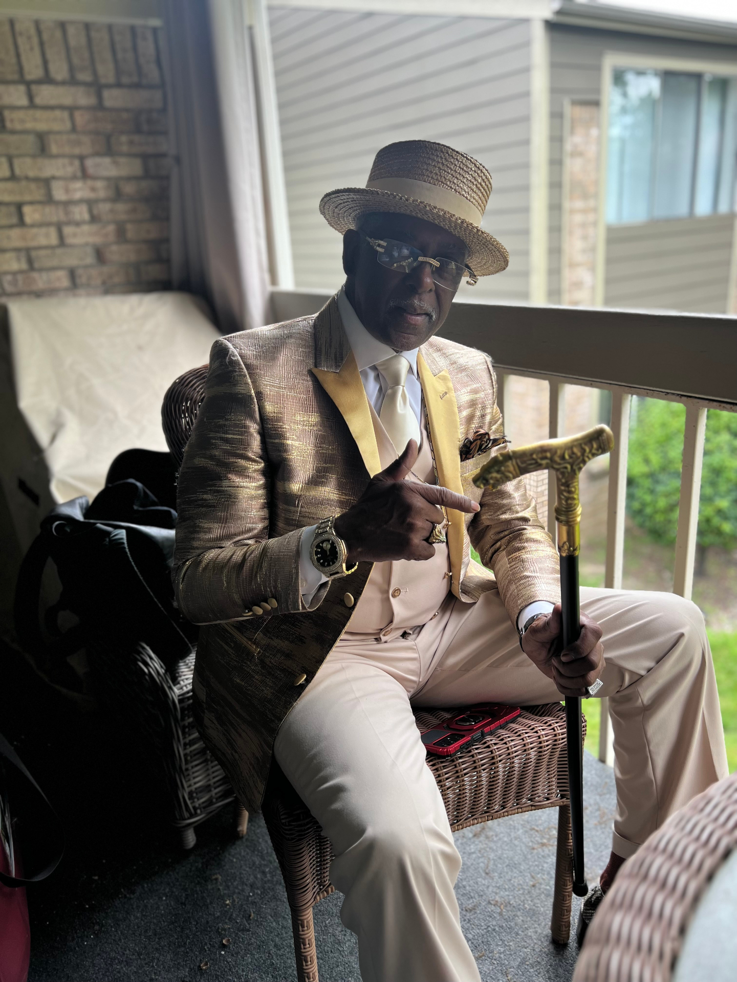 Gold-toned suit with straw boater and cane