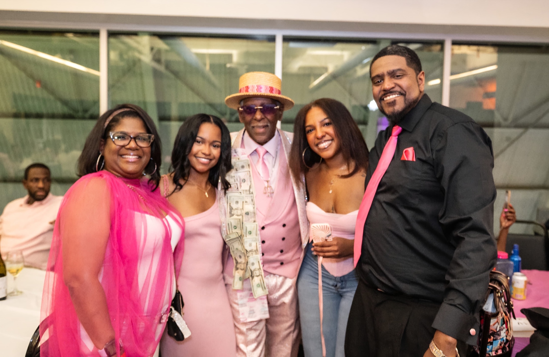 Fast Freddy Anderson in a straw boater hat posing with family at his 80th birthday celebration.
