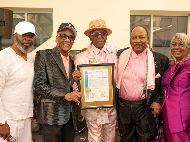 Fast Freddy Anderson holding his Spirit of Detroit Award with Nat Morris, RJ Watkins and guests at his 80th birthday celebration.