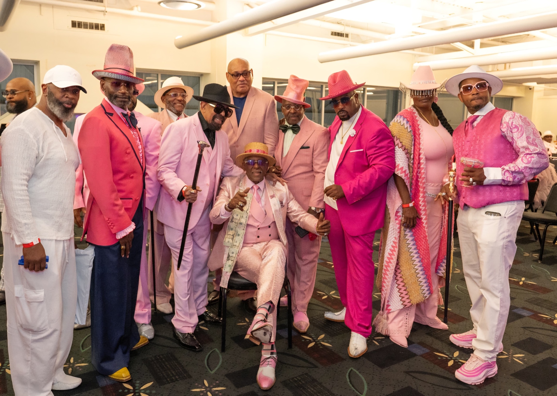 Fast Freddy Anderson seated in pink, surrounded by Detroit gentlemen in pink suits and hats at his 80th birthday celebration.