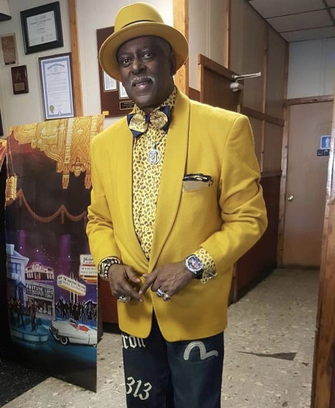 Fast Freddy Anderson in a bright yellow blazer, matching hat and leopard print shirt.