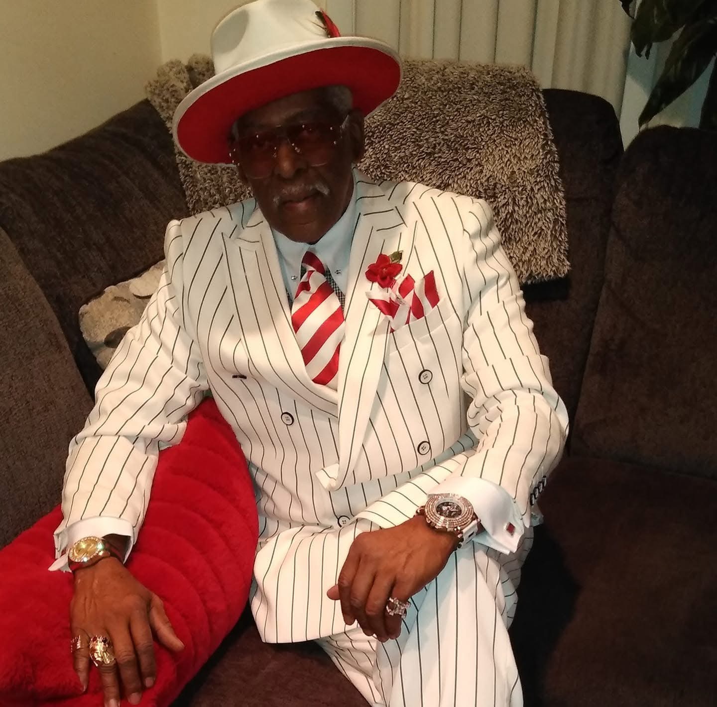 Fast Freddy in a white pinstripe suit with a red-and-white hat and tie