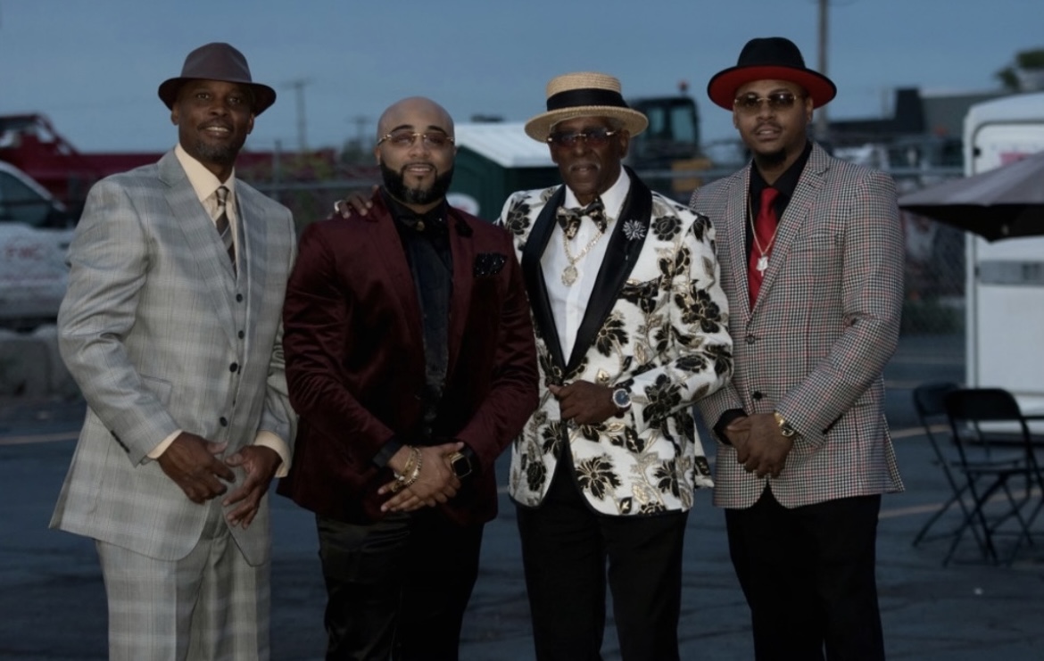 Fast Freddy Anderson lined up outdoors at dusk with three sharply dressed Detroit gentlemen.
