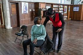 Fast Freddy interacting closely with a seated attendee at a community event